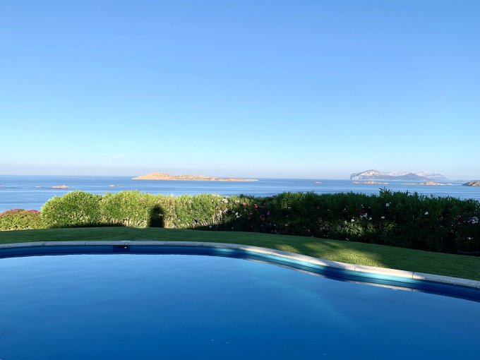 Vista sul mare da una piscina con isole all'orizzonte e cielo sereno.